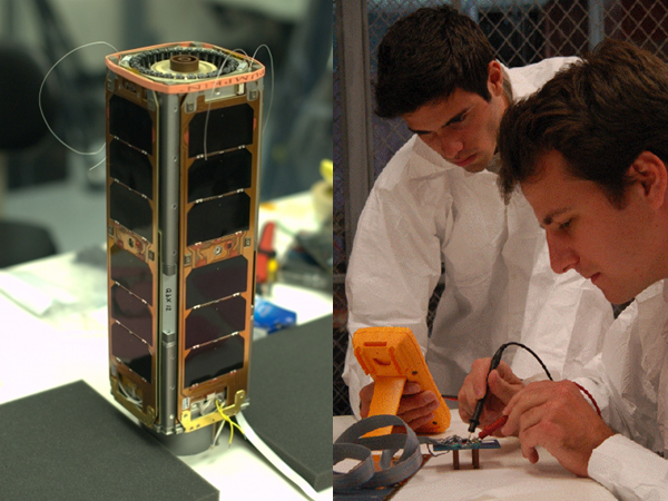 Photo of standing rectangular microsatellite next to students soldering and testing circuit board