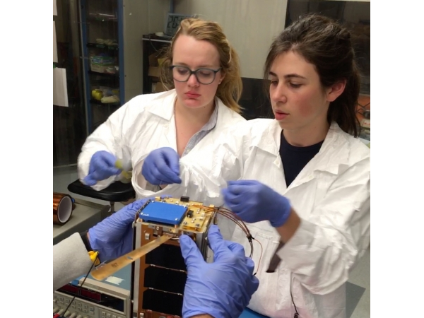Two Students Wearing Lab Coats Working on Circuits