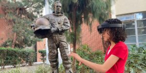 Person Using VR Headset in Front of Neil Armstrong Statue