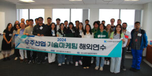 Group of people holding banner in Korean insde office in tall building in front of windows