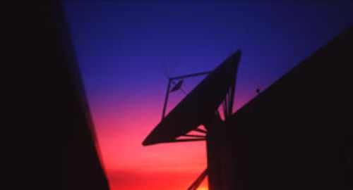 Dark satellite dish during sunrise